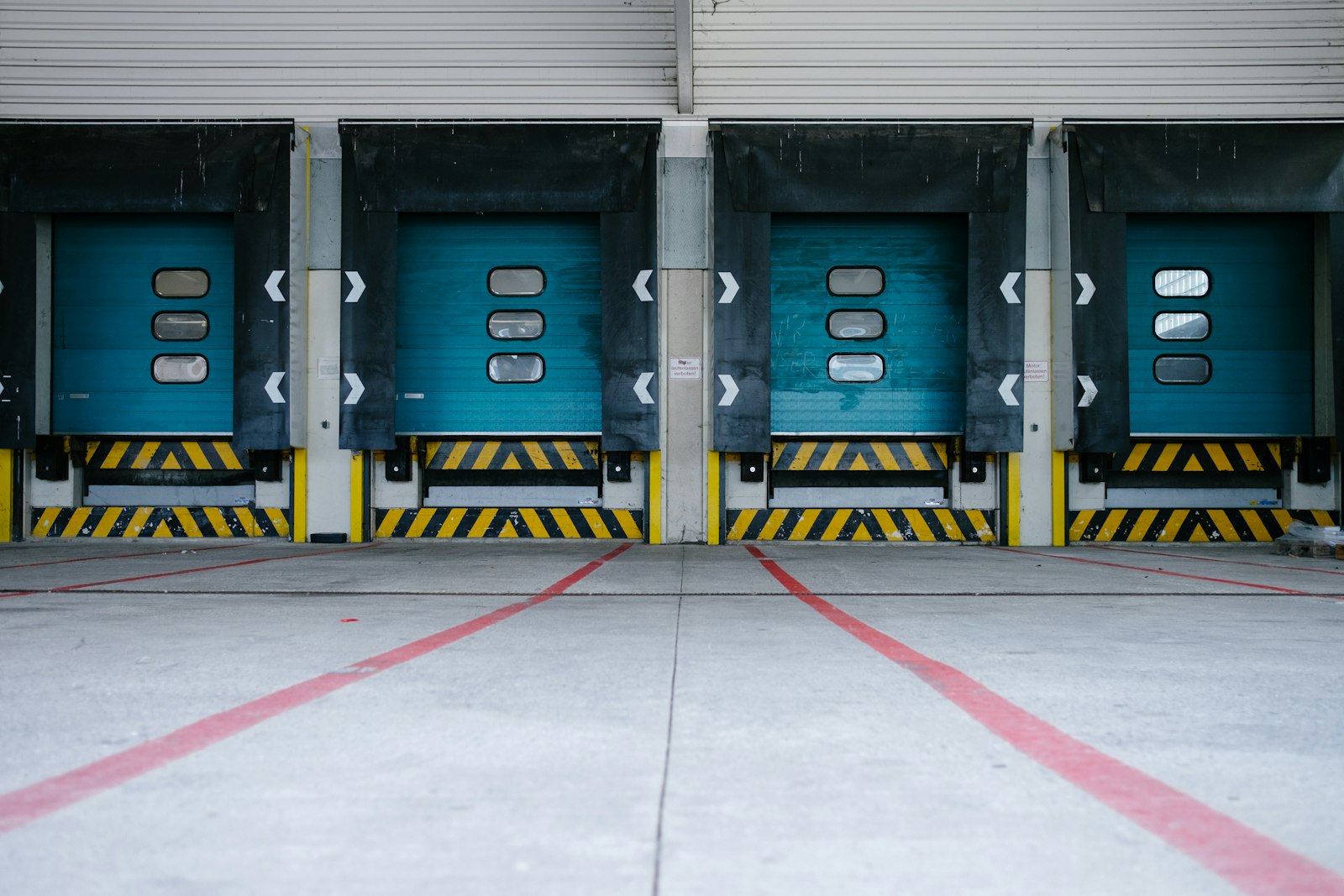 Warehouse loading dock with roll-up door and yellow dock leveler edge